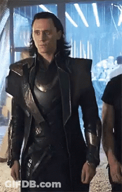A Man In A Black Armored Suit Is Standing In A Room . GIF