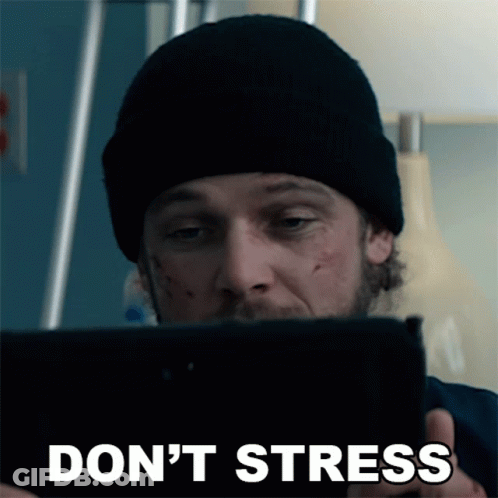 A Man In A Black Beanie Is Looking At A Tablet With The Words " Do N't Stress " On The Bottom GIF