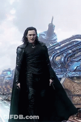 A Man In A Black Cape Is Standing In Front Of A Building GIF
