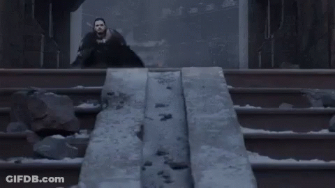 A Man In A Black Cape Is Standing In Front Of A Statue Of A Dragon . GIF