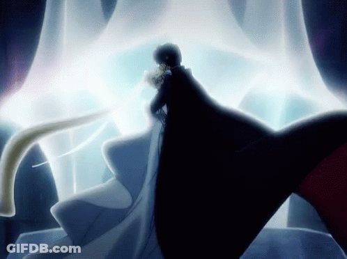 A Man In A Black Cape Is Standing Next To A Woman In A White Gown GIF