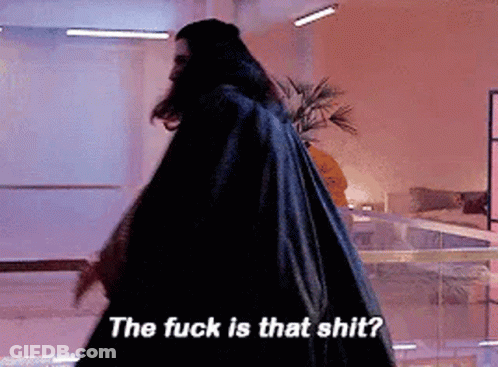 A Man In A Black Cape Is Walking In A Room And Says The Fuck Is That Shit . GIF