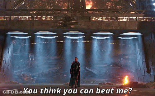 A Man In A Black Cape Stands In Front Of A Building With The Words " You Think You Can Beat Me " Above Him GIF