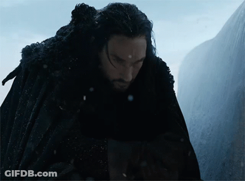 A Man In A Black Cape Stands In Front Of A Mountain GIF