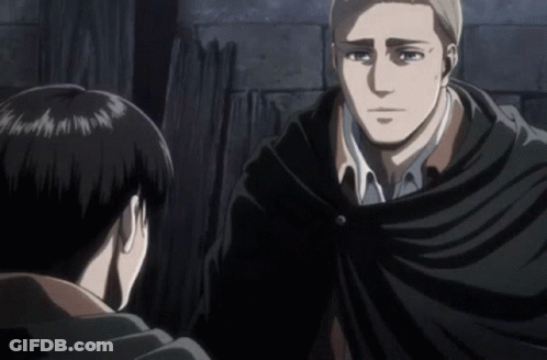 A Man In A Black Cape Talks To Another Man In A White Shirt GIF