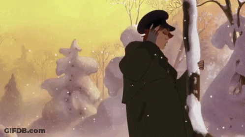A Man In A Black Coat And Hat Is Standing In The Snow Holding A Tree Branch . GIF