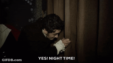 A Man In A Black Coat Is Holding A Curtain And Saying Yes ! Night Time . GIF