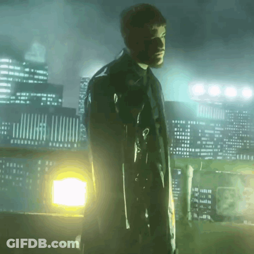 A Man In A Black Coat Is Holding A Gun In Front Of A City Skyline GIF