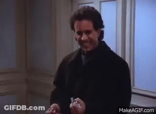 A Man In A Black Coat Is Holding Two Keys In His Hands And Smiling . GIF