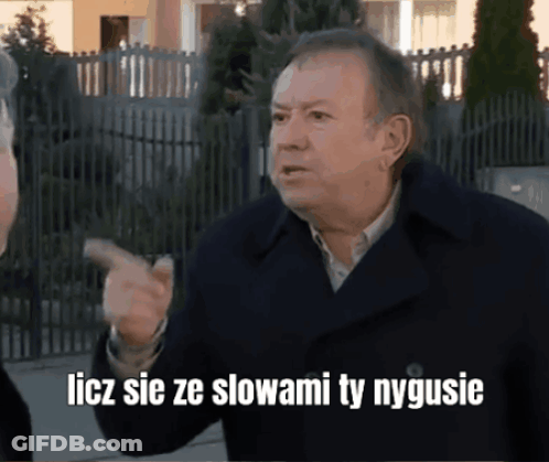 A Man In A Black Coat Is Pointing With The Words Liczy Sie Ze Slowami Ty Nygusie GIF