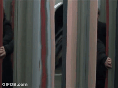 A Man In A Black Coat Is Running Through A Mirrored Room GIF