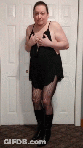 A Man In A Black Dress And Black Boots Stands In Front Of A Door GIF