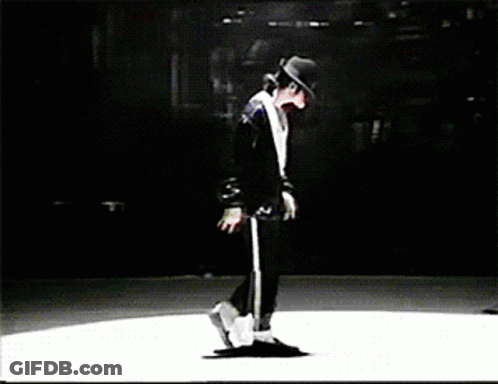 A Man In A Black Hat Is Dancing On A White Stage GIF