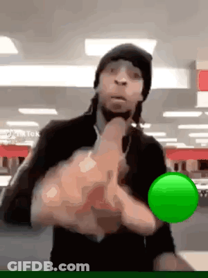 A Man In A Black Hat Is Holding A Green Ball In His Hands . GIF