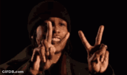 A Man In A Black Hat Is Making A Peace Sign With His Hands GIF