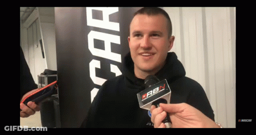A Man In A Black Hoodie Is Being Interviewed By A Person Holding A Microphone That Says Cbn On It GIF