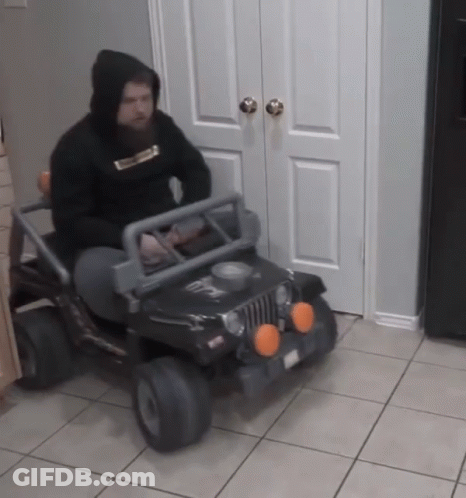 A Man In A Black Hoodie Is Driving A Black Jeep GIF