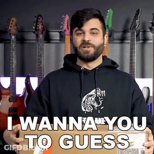 A Man In A Black Hoodie Is Holding A Cardboard Box That Says I Wanna You To Guess GIF