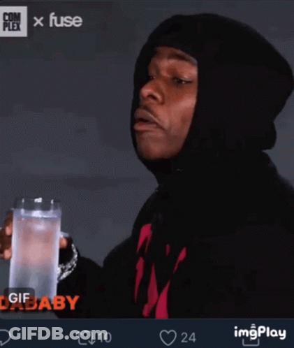 A Man In A Black Hoodie Is Holding A Glass Of Water In His Hand GIF