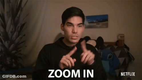 A Man In A Black Hoodie Is Making A Sign That Says Zoom In GIF