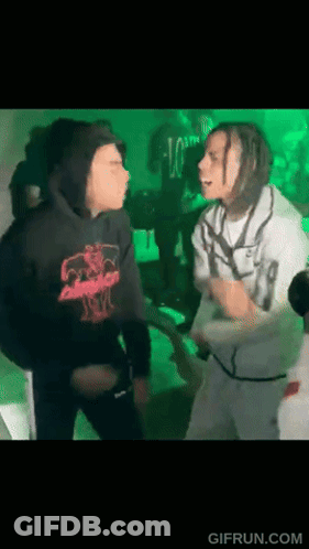 A Man In A Black Hoodie Is Standing Next To A Man In A White Shirt . GIF