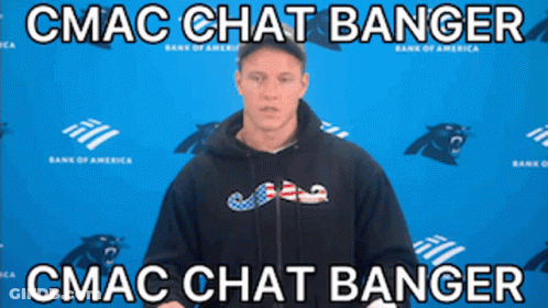 A Man In A Black Hoodie Stands In Front Of A Blue Wall With Panthers On It GIF