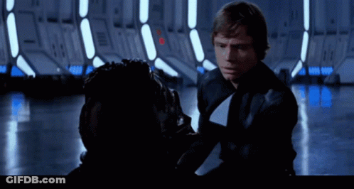 A Man In A Black Jacket And Tie Is Talking To Another Man GIF