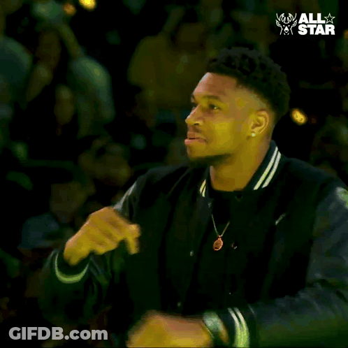 A Man In A Black Jacket Is Dancing In Front Of A Crowd With The Words " All Star " On The Bottom GIF