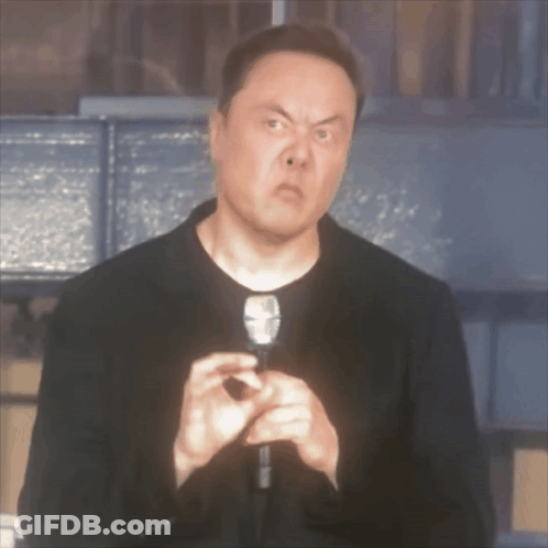 A Man In A Black Jacket Is Holding A Microphone And Making A Face GIF
