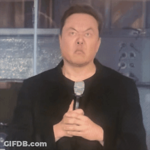 A Man In A Black Jacket Is Holding A Microphone GIF