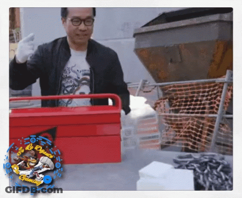 A Man In A Black Jacket Is Holding A Red Toolbox With A Picture Of A Monkey On The Bottom Right GIF