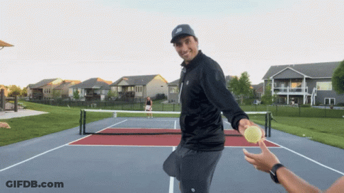 A Man In A Black Jacket Is Holding A Tennis Ball GIF
