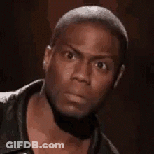A Man In A Black Jacket Is Making A Funny Face . GIF