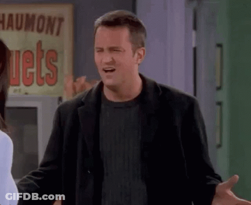 A Man In A Black Jacket Is Making A Funny Face In Front Of A Sign That Says Jets . GIF