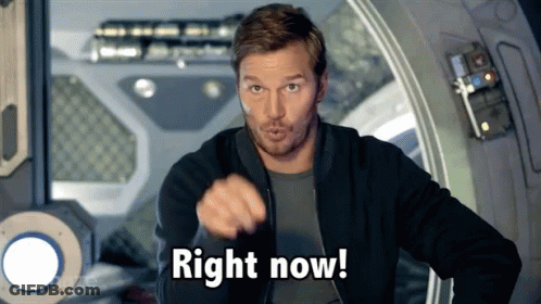 A Man In A Black Jacket Is Pointing At The Camera And Saying Right Now GIF