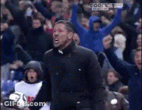 A Man In A Black Jacket Is Screaming In Front Of A Crowd That Is Cheering GIF