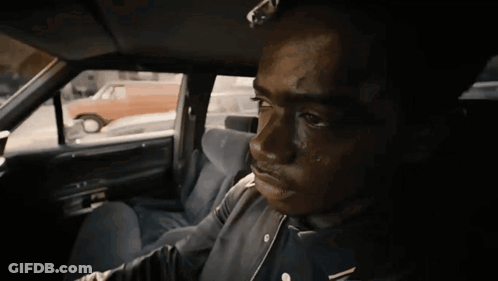 A Man In A Black Jacket Is Sitting In A Car GIF
