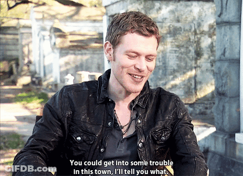 A Man In A Black Jacket Is Smiling And Saying " You Could Get Into Some Trouble In This Town I 'Ll Tell You What " GIF