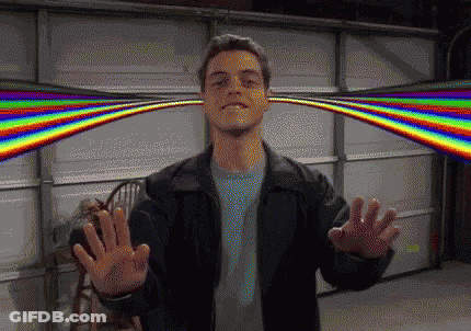 A Man In A Black Jacket Is Standing In Front Of A Garage Door With A Rainbow Behind Him GIF