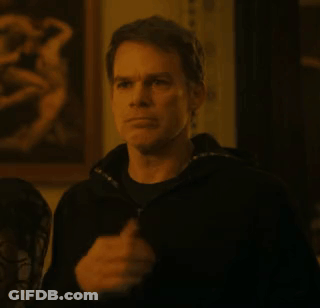 A Man In A Black Jacket Is Standing In Front Of A Painting In A Room . GIF