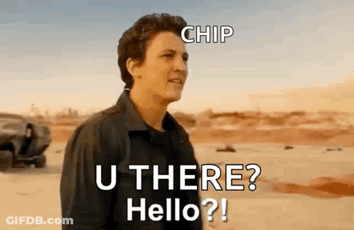 A Man In A Black Jacket Is Standing In The Desert Talking To Someone . GIF