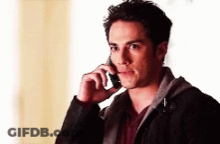 A Man In A Black Jacket Is Talking On His Cell Phone GIF