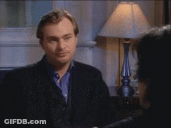 A Man In A Black Jacket Is Talking To Another Man GIF