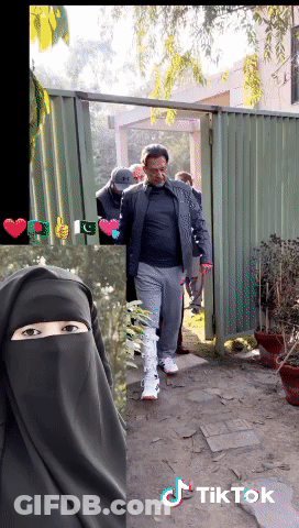 A Man In A Black Jacket Is Walking Through A Gate Next To A Woman In A Niqab And A Tiktok Logo GIF
