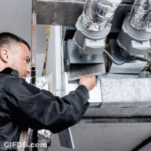 A Man In A Black Jacket Is Working On A Ventilation System With The Number 219 On It GIF