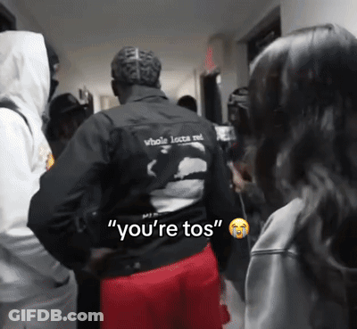 A Man In A Black Jacket Says " You 'Re Tos " To A Woman GIF