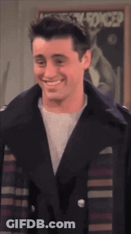 A Man In A Black Jacket Smiles In Front Of A Poster That Says Lucky Forced GIF