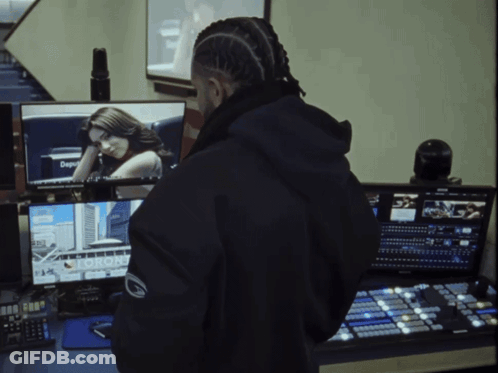 A Man In A Black Jacket Stands In Front Of A Computer Screen That Says Toronto GIF