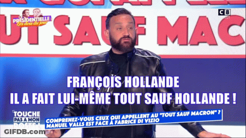 A Man In A Black Jacket Stands In Front Of A Sign That Says Francois Hollande GIF