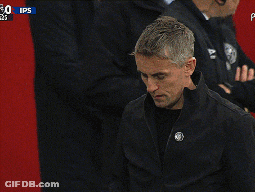 A Man In A Black Jacket Stands In Front Of A Sign That Says Ips On It GIF